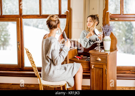 Frau sitzt am Schminktisch im Winter Stockfoto