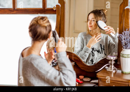 Frau sitzt am Schminktisch im Winter Stockfoto