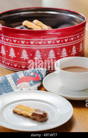 Tasse Tee mit chocloate Kekse mit festlichen Serviette. Stockfoto