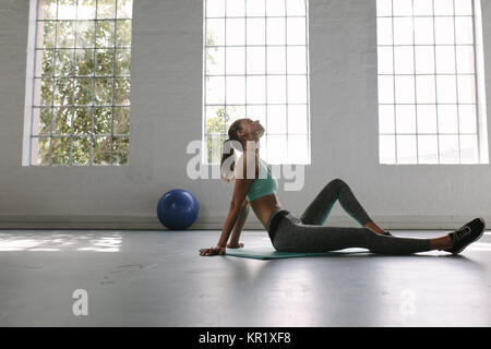 Müde Frau Rest nach Training. Müde und weiblichen Athleten sitzen auf dem Boden im Fitnessstudio erschöpft. Stockfoto