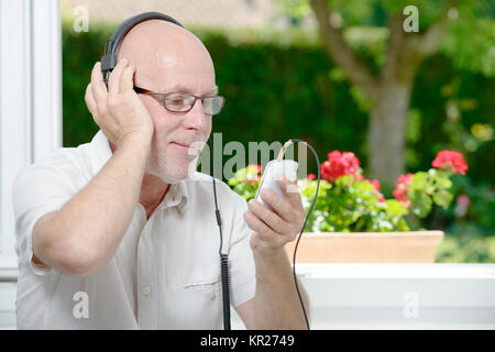 Reifer mann Hören von Musik Stockfoto