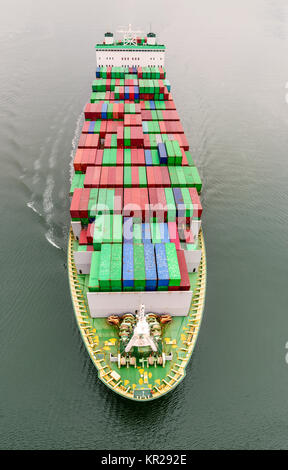 Blick von oben auf eine lange moderne Schiff - ein Containerschiff schwimmen im Meer entlang der Wellen Stockfoto