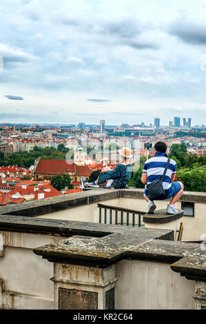 Die Menschen nehmen Bilder von jedem anderen auf der Aussichtsplattform von Prag, Sitzen auf der Attika. Schöne Aussicht auf die Altstadt und die Karlsbrücke. Die Stockfoto