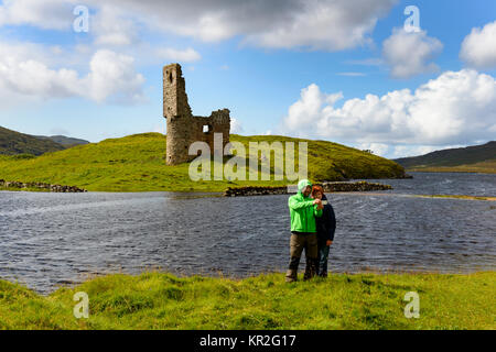 Walker auf den Ruinen der MacLeods von Assynt, Ardvreck Castle am Loch Assynt, Sutherland, Highlands, Schottland, Großbritannien Stockfoto