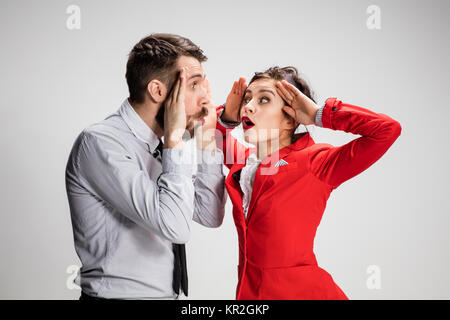 Business-Mann und Frau kommunizieren auf grauem Hintergrund Stockfoto