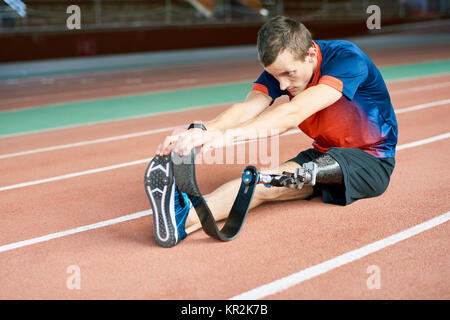 Behinderte Sportler Stretching im Stadion Stockfoto