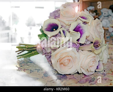 Foto von Weiß und Lila Brautstrauß. Lila-throated calla Lilien, Lavendel Hortensien, Rosen und bunte pittosporum. Dramatisch! Stockfoto