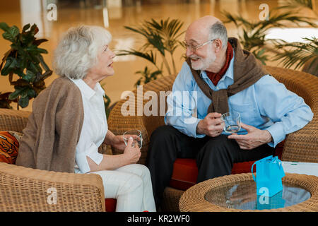 Ältere Paare im Cafe sitzen, lächelnd und miteinander reden Stockfoto