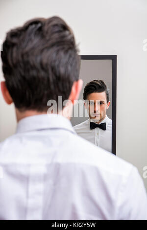 In der Nähe von schöner Mann in Bow-tie auf Spiegel Stockfoto