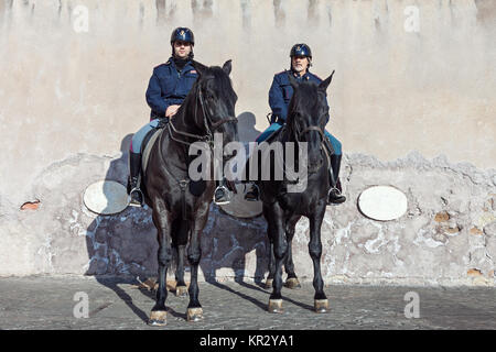 Zwei metropolitan Polizisten patrouillieren Straße auf schwarzen Pferden in Rom, Italien Stockfoto