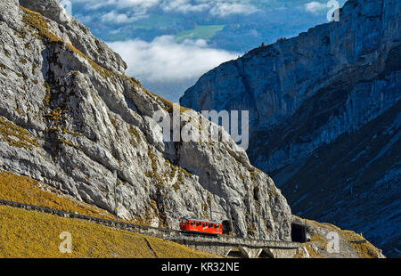 Rote Triebwagen der Pilatus Eisenbahn in eine steile Passage, in der Pilatus massiv, Alpnachstad in der Nähe von Luzern, Schweiz Stockfoto