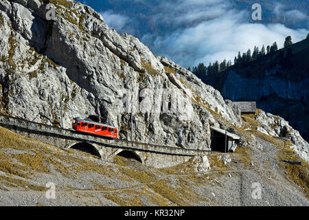 Rote Triebwagen der Pilatus Eisenbahn in eine steile Passage, in der Pilatus massiv, Alpnachstad in der Nähe von Luzern, Schweiz Stockfoto