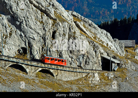 Rote Triebwagen der Pilatus Eisenbahn in eine steile Passage, in der Pilatus massiv, Alpnachstad in der Nähe von Luzern, Schweiz Stockfoto