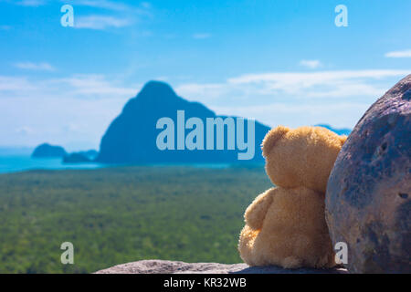 Eine Puppe Bär sitzen auf dem Felsen, um die schöne Landschaft der Inseln in der Andaman See. Stockfoto