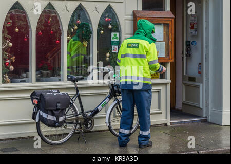 Briefträger der Post die Buchstaben auf einem Fahrrad in Skibbereen, West Cork, Irland. Stockfoto