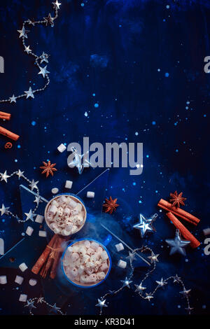 Weihnachten flach mit silber Spielzeug, Dekorationen, Zimt, Anis Sterne und heiße Schokolade mit Marshmallows auf einem tiefen Blau Holz- Hintergrund. Neues Jahr Stockfoto