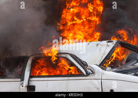 Brennen und löschen Sie ein altes weißes Auto - Übung Feuerwehr Stockfoto