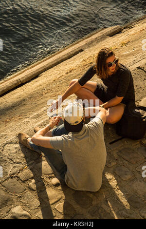 Junge Menschen entspannen im Sommer am Nachmittag in Île Saint-Louis an den Ufern der Seine in Paris, Frankreich Stockfoto