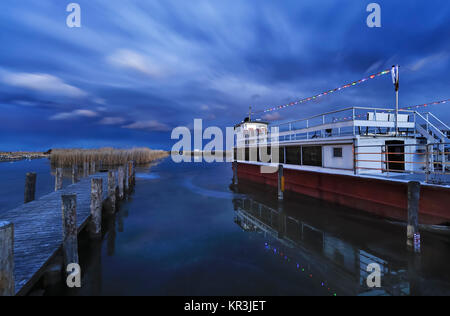 Boot am Pier auf dem See im Winter Stockfoto