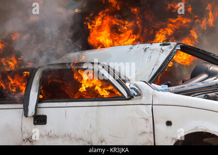 Brennen und löschen Sie ein altes weißes Auto - Übung Feuerwehr Stockfoto