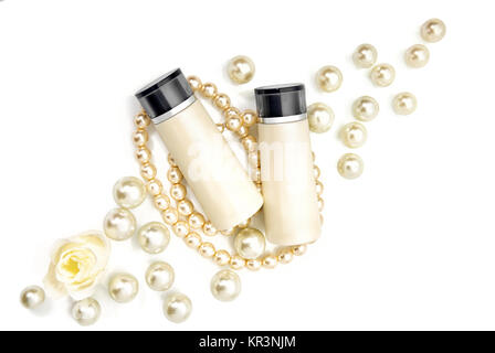 Zwei leere kosmetische Flaschen liegend auf Perlen Stockfoto