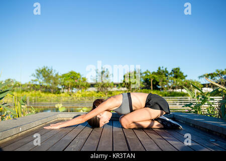 Frau in Yoga pose im Park Stockfoto