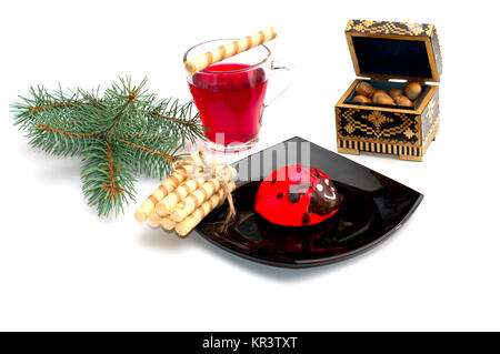 Schild mit rotem Kuchen, Tee, nutlets und ein Nadelholz Zweig Stockfoto