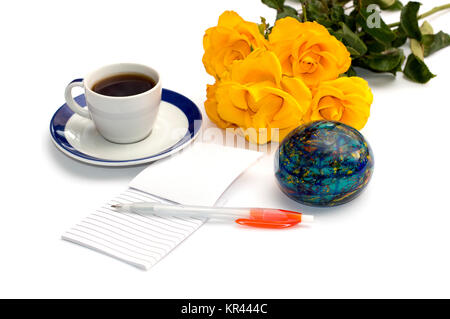 Bouquet von gelben Rosen, Kaffee, dem Globe und Notebook mit dem Griff zu isolieren Stockfoto