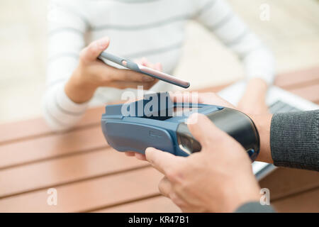 Bezahlen mit Smartphone auf pos-terminal Stockfoto