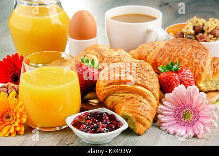 Das Frühstück besteht aus Croissants, Kaffee, Obst, Orangensaft Stockfoto