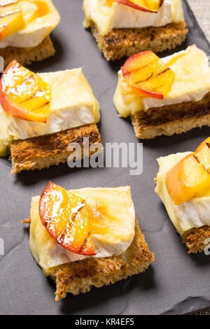 Kanapees mit gegrillten Brie und Nektarine Stockfoto