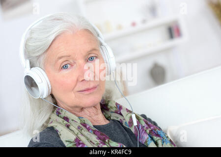 Alte Dame mit Kopfhörer auf Stockfoto
