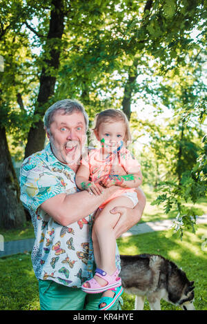 Zwei - jährigen Mädchen in Farben gegen grünen Rasen gebeizt Stockfoto