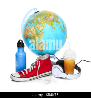 Der blaue Globus, Turnschuhe, Thermoskanne und Kopfhörer auf weißem Hintergrund. Stockfoto