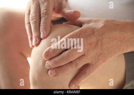 Senior hat die Hände auf seine Schmerzende Knie Stockfoto