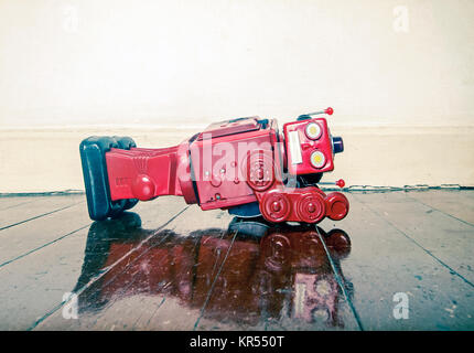 Über arbeitete Retro rot Roboter verdeckt auf alten Holzboden mit Reflexion Stockfoto