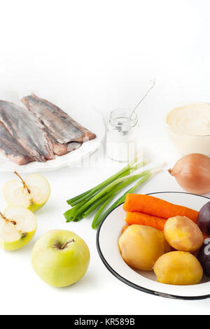 Zutaten für Salat mit Apfel und Fisch auf dem weißen Hintergrund vertikal Stockfoto