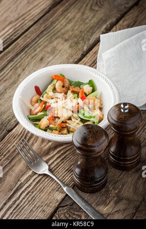 Caesar Salat mit Salz- und Pfefferstreuer und Gabel vertikale Stockfoto