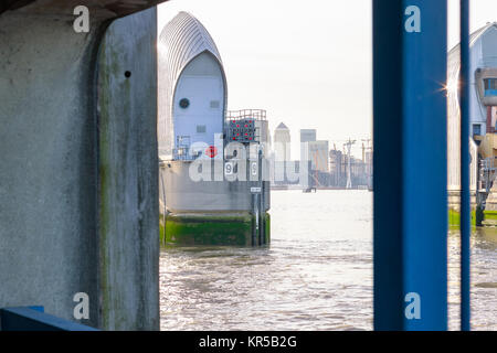 Thames Barrier mit Canary Wharf im Hintergrund von einem flußufer Aussichtsplattform in London gerahmt Stockfoto