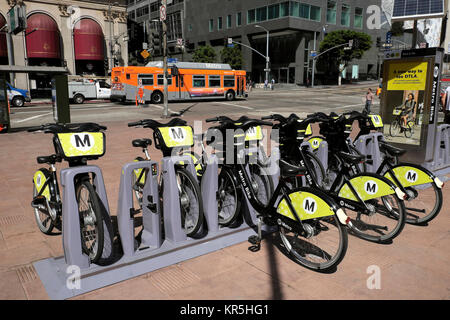Street Scene von M Fahrräder in einem fahrradständer und eine orange Metro Bus in der Nähe von Pershing Square in der Innenstadt von Los Angeles, Kalifornien USA KATHY DEWITT Stockfoto