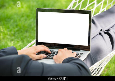 Person in der Hängematte mit Laptop Stockfoto