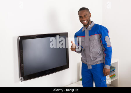 Techniker in der Nähe des Fernseher mit Daumen hoch Stockfoto
