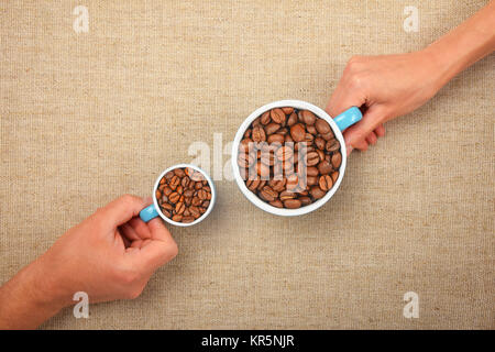 Zwei Hände mit gerösteten Kaffeebohnen in Cups Stockfoto