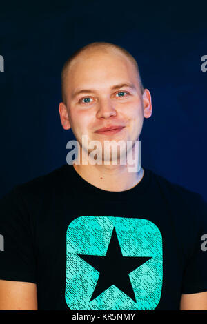 Jungen Kerl balding in eine Weste auf einem dunklen Hintergrund Stockfoto