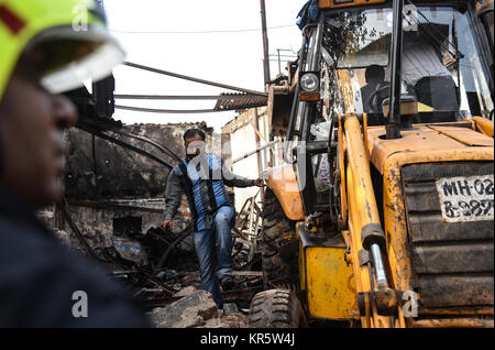 Mumbai. 18 Dez, 2017. Arbeitnehmer klare Rückstände von einem Feuer Unfall in Mumbai am Dez. 18, 2017. Mindestens 12 Menschen wurden getötet und vier andere bei einem Brand in einem Geschäft in der indischen Hauptstadt verletzt Montag, sagte die Polizei. Quelle: Xinhua/Alamy leben Nachrichten Stockfoto