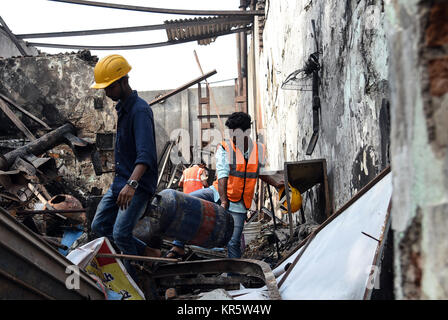 Mumbai. 18 Dez, 2017. Arbeitnehmer klare Rückstände von einem Feuer Unfall in Mumbai am Dez. 18, 2017. Mindestens 12 Menschen wurden getötet und vier andere bei einem Brand in einem Geschäft in der indischen Hauptstadt verletzt Montag, sagte die Polizei. Quelle: Xinhua/Alamy leben Nachrichten Stockfoto