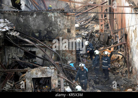 Mumbai. 18 Dez, 2017. Feuerwehrleute untersuchen Sie die verbrannten Shop in Mumbai, Dez. 18, 2017. Mindestens 12 Menschen wurden getötet und vier weitere verletzt bei einem Brand in einer Werkstatt in der indischen Hauptstadt Montag, sagte die Polizei. Quelle: Xinhua/Alamy leben Nachrichten Stockfoto