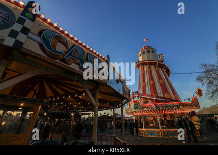 London, Großbritannien. 18 Dez, 2017. Menschen nutzen das wärmere Wetter genießen Sie die Sonne am Nachmittag auf der Winter Wunderland im Hyde Park. mit mehreren festliche Märkte, über 100 Fahrgeschäfte und Attraktionen ein Riesenrad, zahlreichen Live Shows, darunter ein Zirkus, Eis, und live Musik, sowie zahlreiche Bars und Restaurants. Winter Wonderland hat 14 Millionen Besucher, seit sie 2007 ins Leben gerufen wurde. Credit: Amer ghazzal/Alamy leben Nachrichten Stockfoto