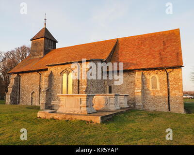 Harty, Kent, Großbritannien. 18 Dez, 2017. UK Wetter: Ein schöner Winter Sonnenuntergang hinter der Kirche 'St. Der Apostel Thomas' (Grad II) nach der 11. oder frühen 12. Jahrhundert, an Harty auf der Insel Sheppey in Kent. Oft als Kent's entlegensten Ort der Anbetung beschrieben. Credit: James Bell/Alamy leben Nachrichten Stockfoto