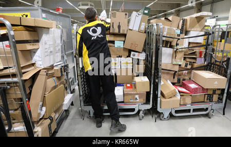 Die eingehenden Pakete werden in den Dienst der Deutschen Post und DHL in Rostock, Deutschland sortiert, 19. Dezember 2017. Derzeit werden die Dienstleister haben eine Hochphase der Arbeit. Die Menge der Pakete und Briefe sind in der Zeit vor Weihnachten verdoppelt. Allein in Mecklenburg-Vorpommern gibt es mehr als 220 zusätzliche Lieferanten in der Lieferung Abteilung beschäftigt. Foto: Bernd Wüstneck/dpa Stockfoto